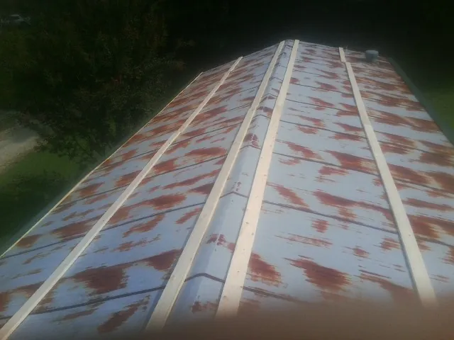 Rusted metal roof panels with new wood purlins before replacement — Storm Damage Roof Repair in Bogota by Roofing Brothers