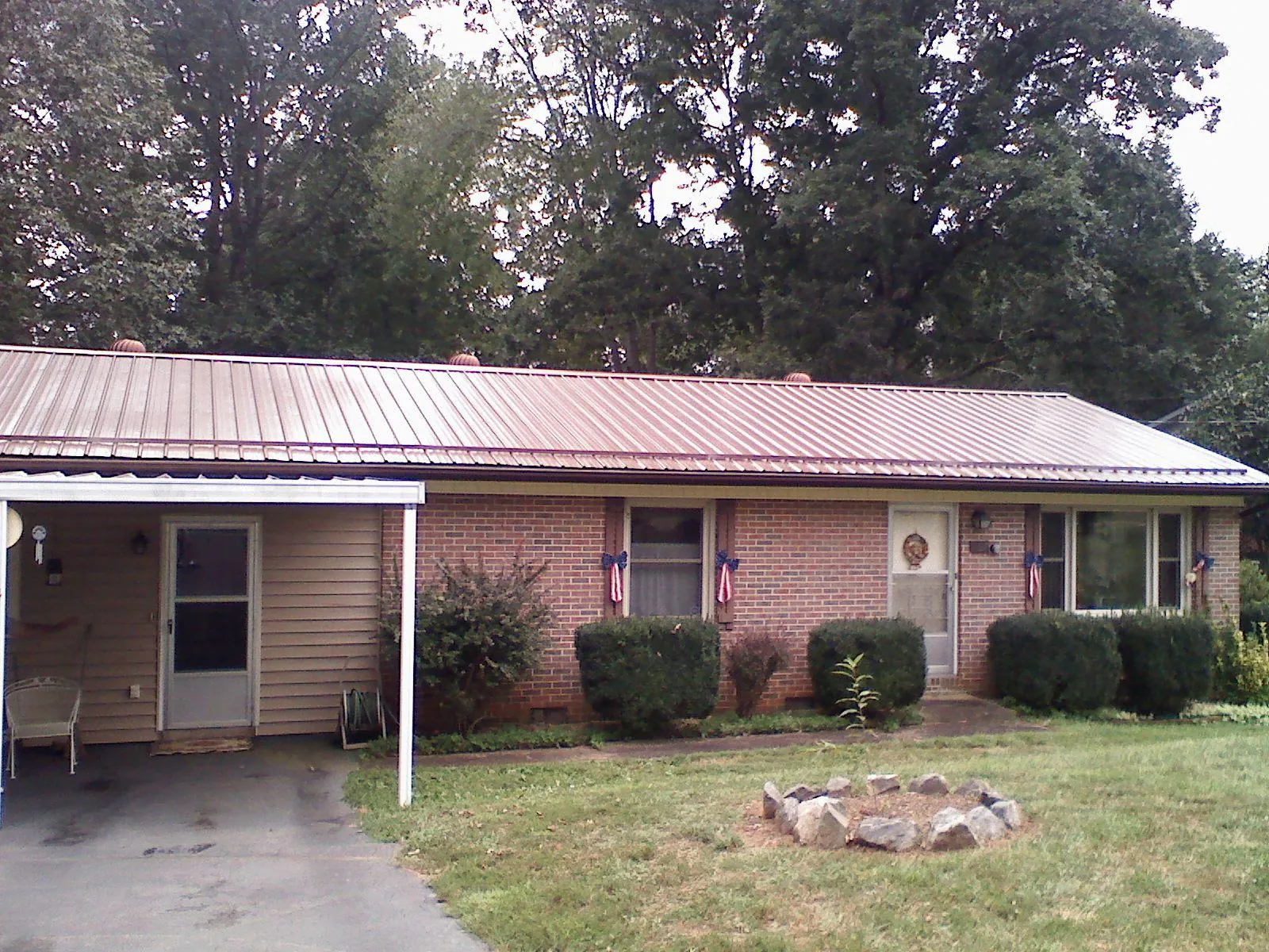 Bronze metal roof and carport on a brick ranch home — Roof Repair work by our crew in Bogota